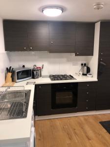 uma cozinha com armários pretos e um forno com placa de fogão em Town Centre Apartment with FREE Parking em Loughborough