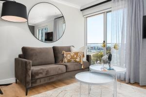 a living room with a couch and a mirror at Point Break Luxury Apartments in Cape Town