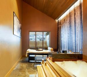 a bathroom with a large window and a tub at Kaya Palazzo Ski & Mountain Resort in Kartalkaya