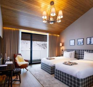 a hotel room with two beds and a desk and a chair at Kaya Palazzo Ski & Mountain Resort in Kartalkaya