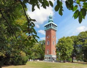 a tall brick tower with a green roof at Town Centre Apartment with FREE Parking in Loughborough