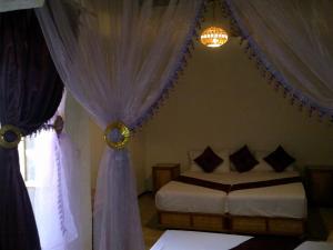 a bedroom with a bed and curtains and a window at Riad Azrou in Azrou
