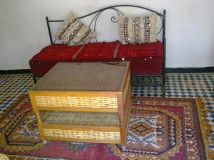 1 dormitorio con 1 cama con mesa y alfombra en Riad Azrou, en Azrou