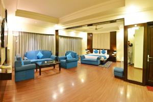 a living room with blue furniture and a bed at Indraprastha Resort Dalhousie in Dalhousie