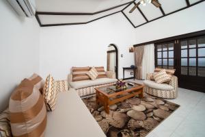 uma sala de estar com sofás e uma mesa de centro em PrideInn Flamingo Beach Resort & Spa Mombasa em Mombasa