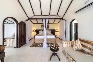 um quarto com uma cama e um sofá em PrideInn Flamingo Beach Resort & Spa Mombasa em Mombasa