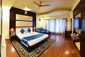 a hotel room with a large bed and a television at Indraprastha Resort Dalhousie in Dalhousie