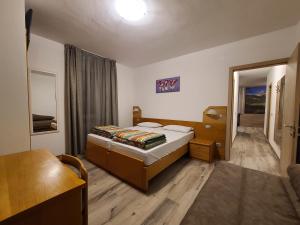ein Schlafzimmer mit einem Bett und einem Sofa darin in der Unterkunft Al Toscana in Andalo