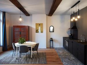 een keuken en eetkamer met een tafel en stoelen bij La Petite Histoire gîtes-appartements in Aat