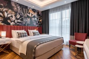a bedroom with a large bed and a large window at Motif Hotel Çeşme in Çeşme