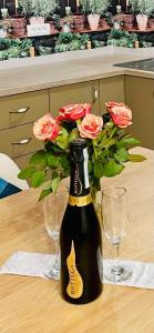 una bottiglia di champagne con rose in un tavolo di Pensiunea Galileo a Borşa