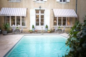 - une piscine en face d'un bâtiment avec fenêtres dans l'établissement Carcassonne Bed and Breakfast du Palais, à Carcassonne