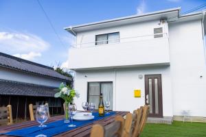 a table with wine glasses and wine bottles on it at Awaji Garden House in Shinmura in Sumoto