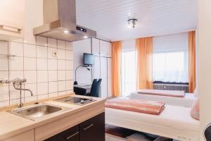 - une cuisine avec évier et un lit dans une chambre dans l'établissement Apartment-EG-03, à Darmstadt