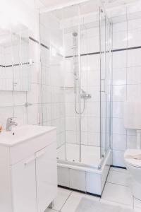 La salle de bains blanche est pourvue d'une douche et de toilettes. dans l'établissement Apartment-EG-03, à Darmstadt