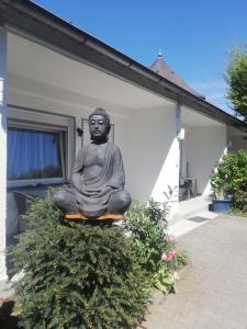 a statue of a buddha sitting on the side of a house at Apartment-EG-03 in Darmstadt