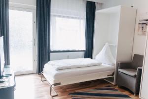 ein Schlafzimmer mit einem Bett, einem Stuhl und einem Fenster in der Unterkunft Apartment EG 07 in Darmstadt