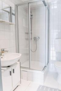 baño blanco con ducha y lavamanos en Apartment-EG-07, en Darmstadt