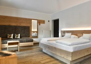 una camera con un grande letto e un grande specchio di Hotel Toblacherhof a Dobbiaco