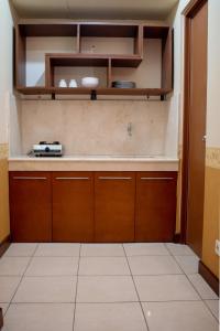a kitchen with wooden cabinets and a counter at Majesty Homey 2BR Apartment in Bandung