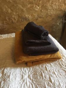 una pila de toallas sentadas encima de una cama en Les Gonies - Amande, en Mauroux