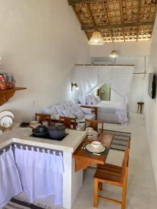 een woonkamer met een bed en een tafel en stoelen bij Flat Pitaya - Cond. Morada da Praia in Bertioga