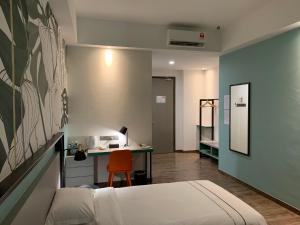 K Hotel في كوتا كينابالو: غرفة نوم بسرير ومكتب وطاولة