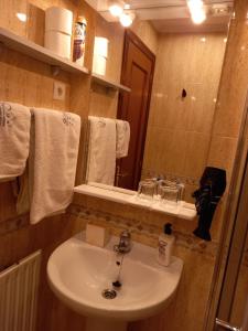 y baño con lavabo, espejo y toallas. en Suite Bilbao Arena con plaza de garaje, en Bilbao