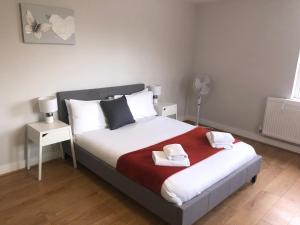 1 dormitorio con 1 cama con 2 toallas en 2 Bedroom Large First Floor Apartment with FREE Parking, en Loughborough