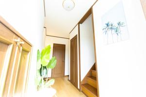 a hallway of a house with a staircase and a plant at Awaji Garden House in Shinmura in Sumoto