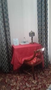 une table rouge avec une chaise et une lampe dans l'établissement Da Betty, à Asti