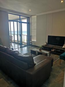 een woonkamer met een bank en een televisie bij 208 Coral Reef in La Mercy