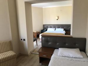 una habitación de hotel con 2 camas y una silla en AFYTOS ÖREN PARK MTK en Burhaniye
