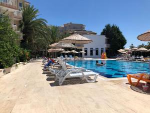 a row of lounge chairs next to a swimming pool at AFYTOS ÖREN PARK MTK in Burhaniye