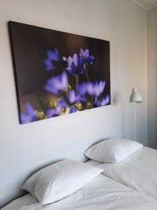 a picture of purple flowers is above a bed at Broholm Bed&Breakfast in Lidköping