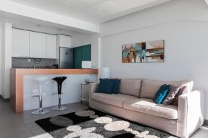 a living room with a couch and a kitchen at Atlantic Ocean View Suite Sesimbra in Sesimbra