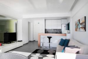 a living room with a couch and a kitchen at Atlantic Ocean View Suite Sesimbra in Sesimbra