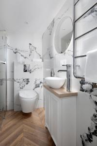 a white bathroom with a sink and a mirror at Elite Apartments Piwna Prestige in Gdańsk +60 photos