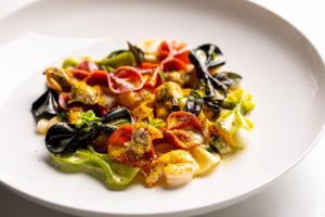 a white plate of food on a white table at Vinilia Wine Resort in Manduria