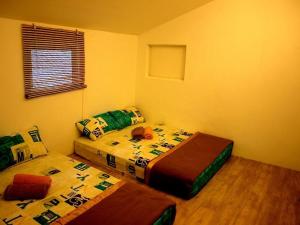 - une chambre avec 2 lits et une fenêtre dans l'établissement Fang Zu Ming Concept Guesthouse, à Ayer Itam