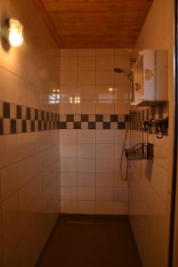 ein Badezimmer mit Dusche mit schwarz-weißen Fliesen in der Unterkunft Vakantiewoning Boerderij De Gerrithoeve in Oisterwijk + 7 Fotos