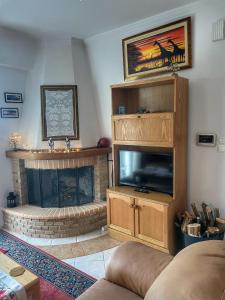 ein Wohnzimmer mit einem Kamin und einem Flachbild-TV in der Unterkunft "Mykines" Apartment of Levidi Arcadian Apartments in Leonidi