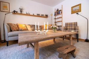 een woonkamer met een houten tafel met kaarsen erop bij Bella Riva by Arosa Holiday in Arosa