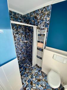 un bagno con wc e parete a mosaico di Villa am Steinhuder Meer Superior DZ-Azur- mit kl Pantry Küche, Garten, WLAN a Steinhude Altre 33 foto