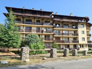 een groot gebouw met een hek ervoor bij Старият Хан-Б24 in Bansko
