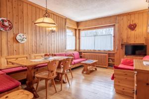 a dining room with a table and a couch at Ca' Milijera in Cortina dʼAmpezzo
