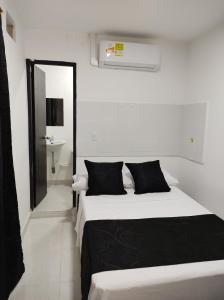 a bedroom with two beds and a mirror at HOTEL BLACK & WHITE in Cali
