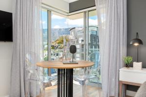 a room with a table and chairs and a large window at Point Break Luxury Apartments in Cape Town