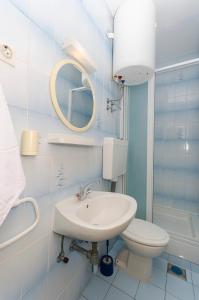 a bathroom with a sink and a toilet and a mirror at Rooms Dejana in Vodice