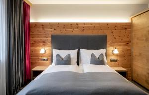 a bedroom with a large bed with two pillows at Ski & Bike Hotel Wiesenegg in Saalbach-Hinterglemm